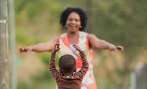 Young child running toward his mother, who is kneeling with arms open