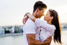 Couple embracing closely, foreheads nearly touching