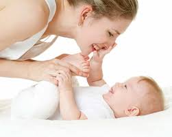 Mother leaning over her smiling baby, touching faces