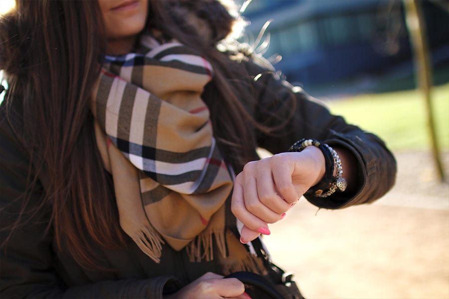 A woman anxiously checking her watch