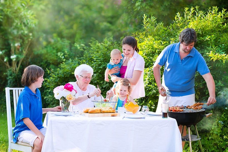 Three generations of a family sharing a meal outdoors