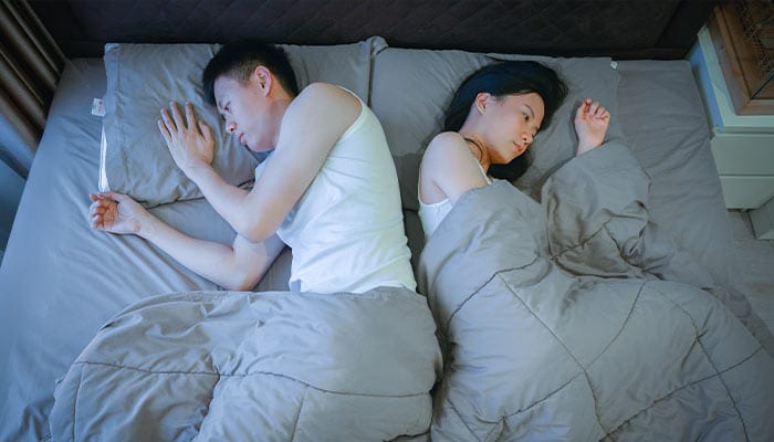 upset couple sleeping back to back