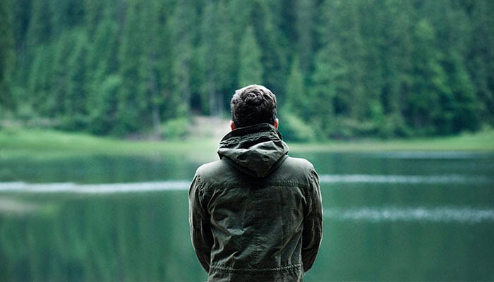 person alone looking at a lake